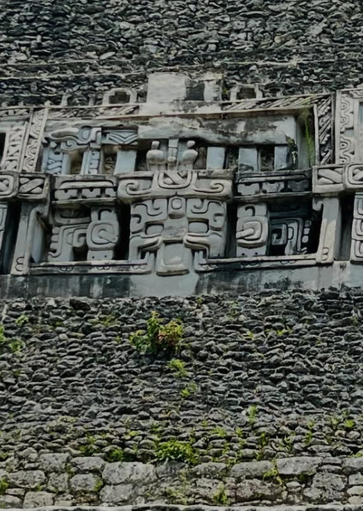Close-up of the stucco frieze on El Castillo, Xunantunich — the visible panels are replicas